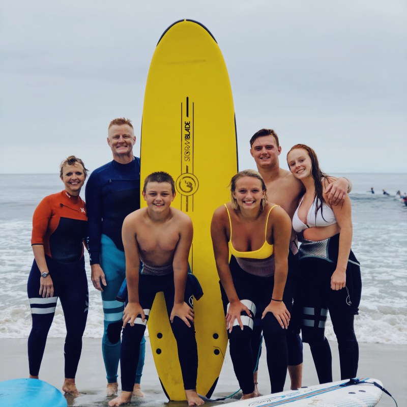 a group of people standing on a beach posing for the camera