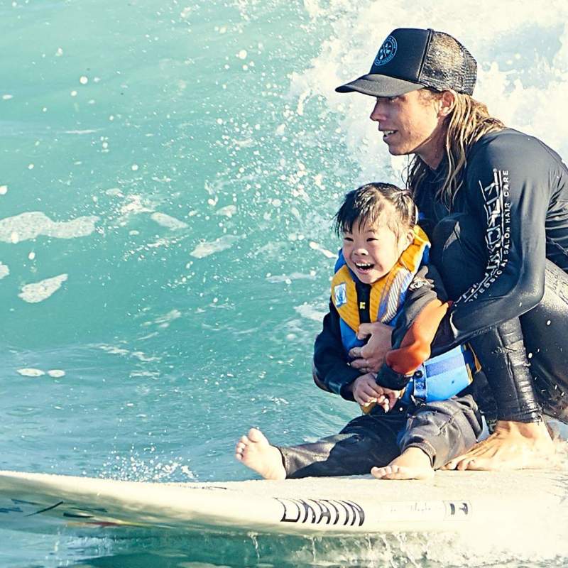 a young girl riding a wave on a surfboard in the water