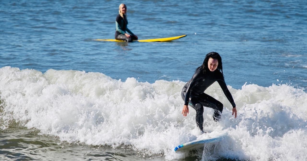 a young girl riding a wave on a surfboard in the ocean