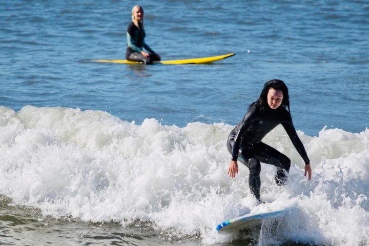 a young girl riding a wave on a surfboard in the ocean
