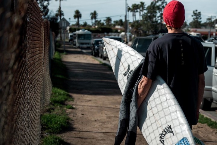 a man wearing a suit and tie walking on a sidewalk