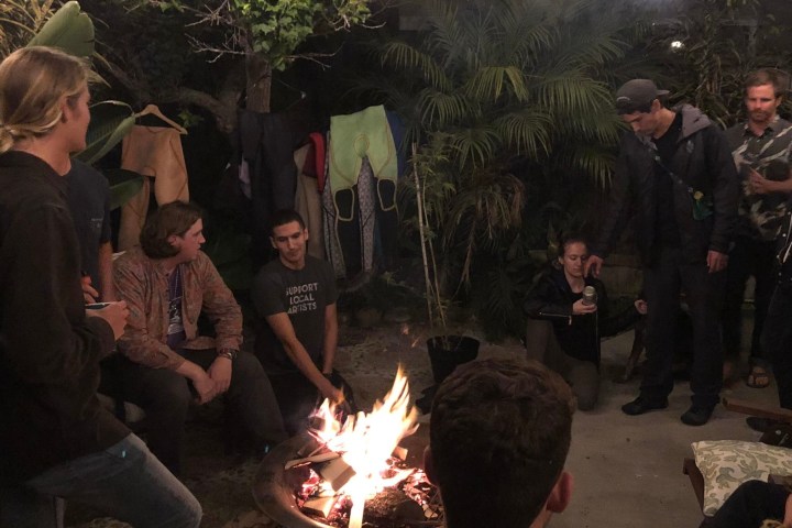 a group of people standing in front of a birthday cake