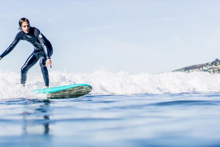 a man riding a wave on a surf board on a body of water