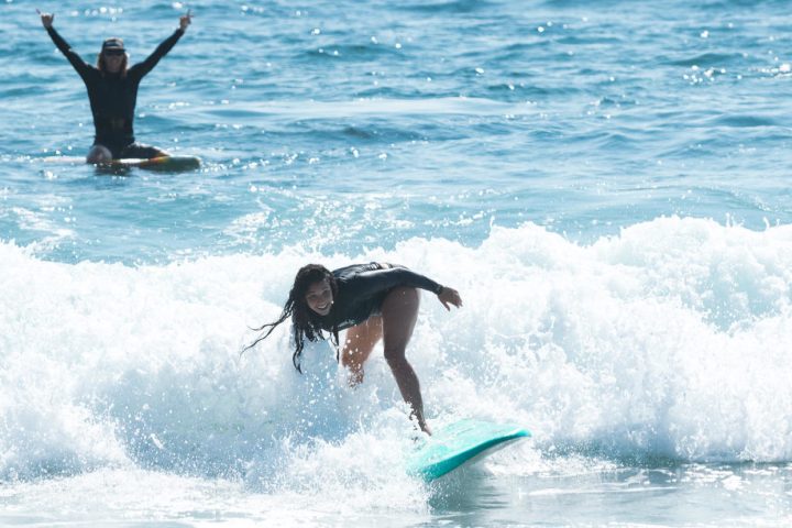a girl riding a wave on a surfboard in the ocean
