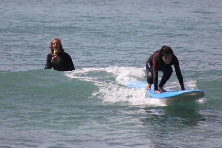 a girl riding a wave on a surfboard in the ocean