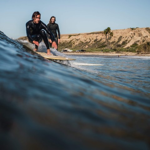 a man riding a wave on a surfboard in the water